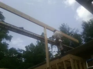Carpenter setting a ridge beam over a new addition frame — Ice Dam Removal by Roofing Brothers in Evergreen Park