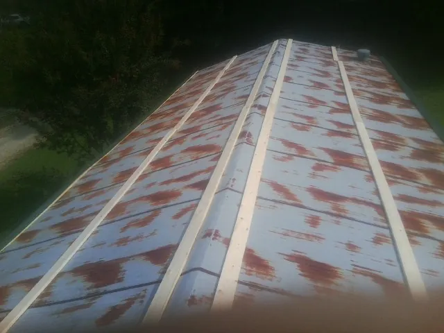 Rusted metal roof panels with new wood purlins before replacement — Storm Damage Roof Repair in Evergreen Park by Roofing Brothers