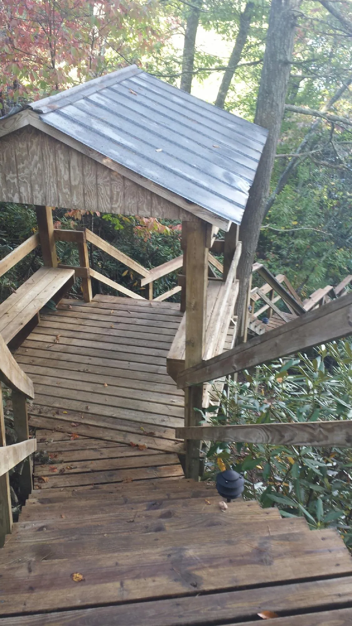 Metal roofed shelter over wooden steps on a wooded walkway — Skylight Repair & Installation work by our crew in Evergreen Park